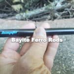 man holding bayite ferro rod over fire pit