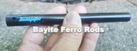 man holding bayite ferro rod over fire pit