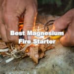 man using magnesium fire starter tool to start campfire